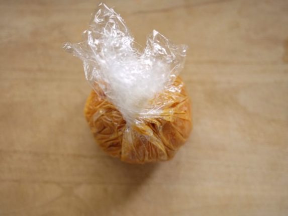 味噌をチーズで包むようにラップの上から伸ばしていく様子
